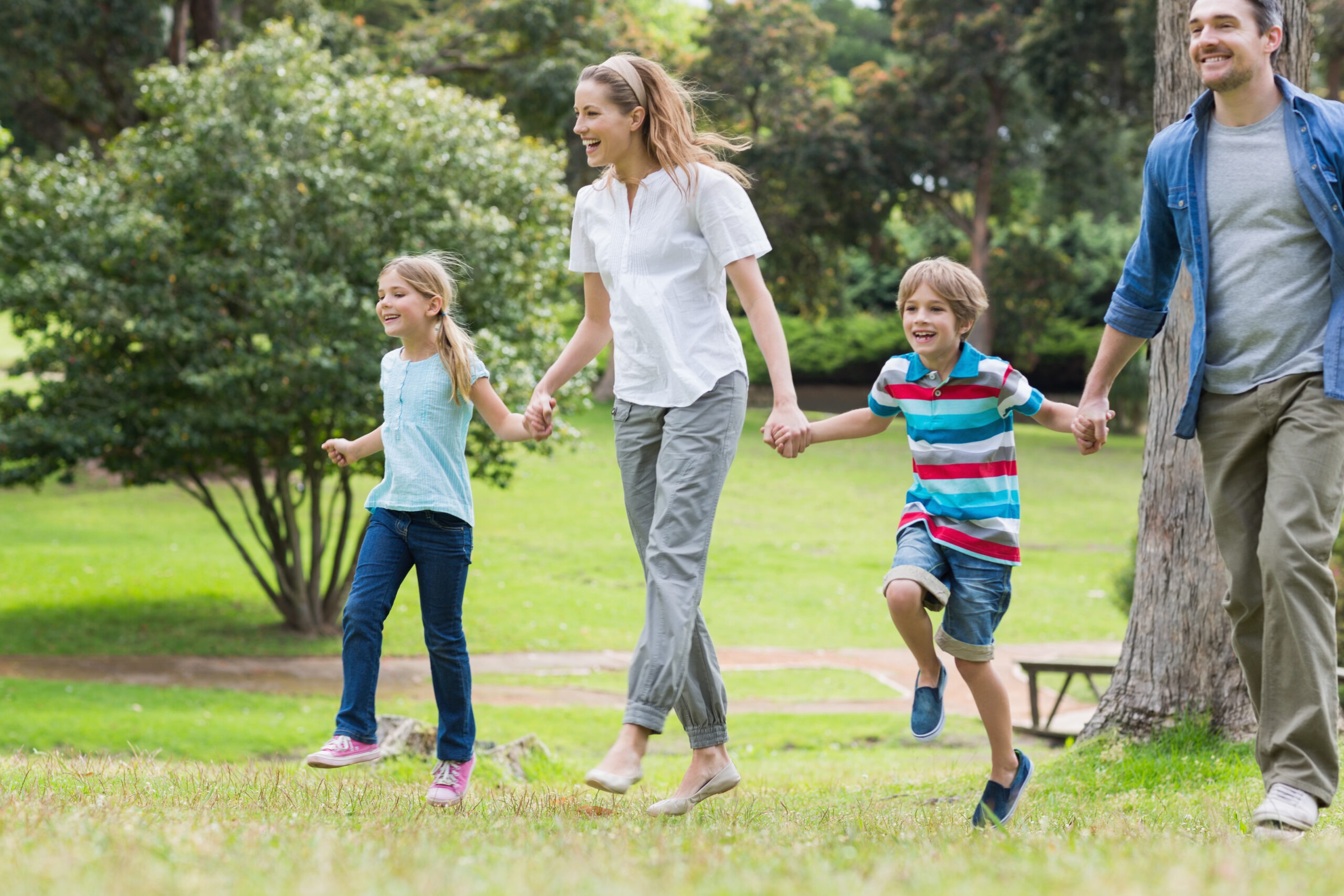 Full,Length,Of,Parents,And,Kids,Walking,In,The,Park